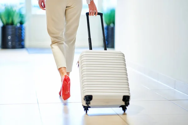Businesswoman with luggage in modern hotel lobby — Stock Photo, Image