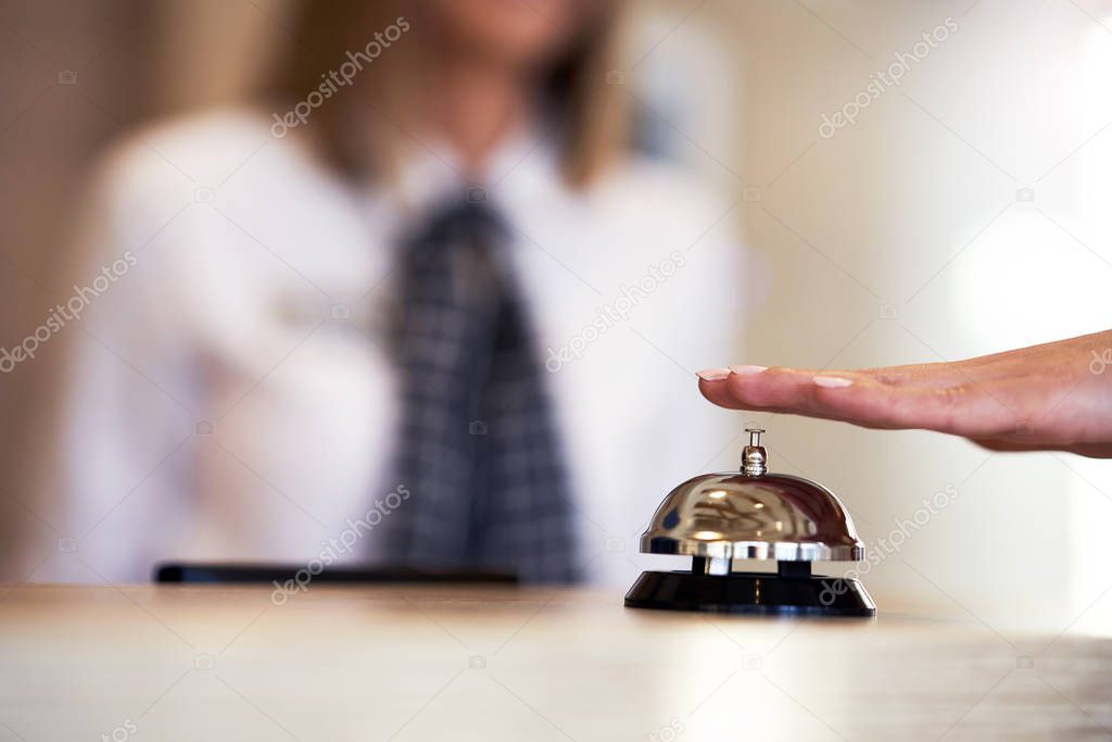 Hotel bell at front desk and receptionist in background