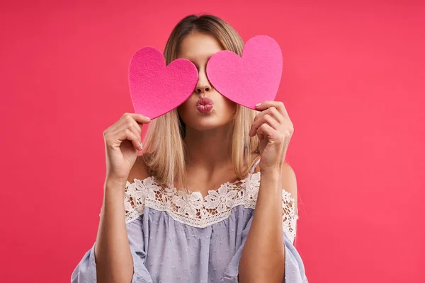 Hermosa mujer adulta posando sobre fondo rosa con corazones —  Fotos de Stock