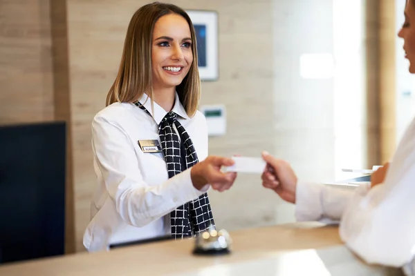 Recepční dává vstupní kartu podnikatelce na recepci hotelu — Stock fotografie