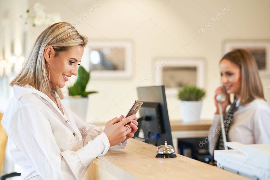 Receptionist and businesswoman at hotel front desk