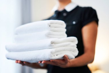 Hizmetçi otel odasında taze havlu ile