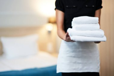 Hizmetçi otel odasında taze havlu ile