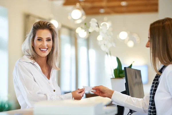 Receptionist and businesswoman at hotel front desk — Stock Photo, Image