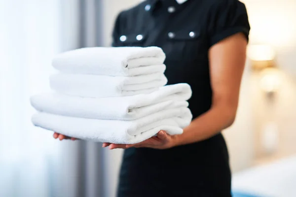 Femme de ménage avec des serviettes fraîches dans la chambre d'hôtel — Photo