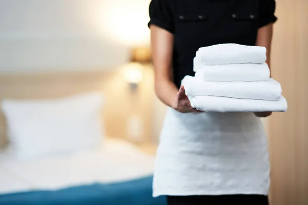Mucama con toallas frescas en habitación de hotel —  Fotos de Stock