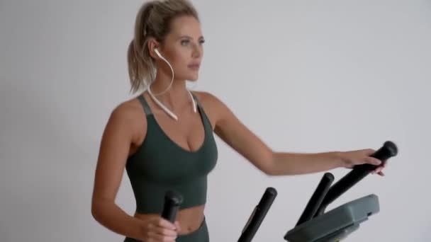 4k mooie vrouw uit te werken op crosstrainer thuis — Stockvideo