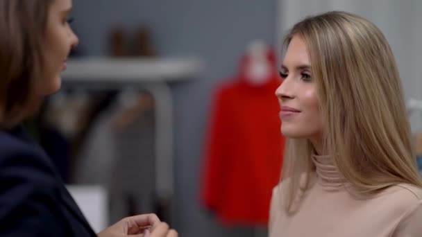 Shop assistant helping customer in clothes shop — Stock Video