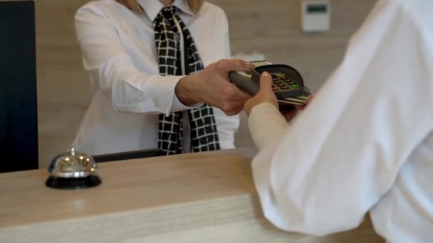 Receptionist assisteren hotelgast aan de balie — Stockvideo