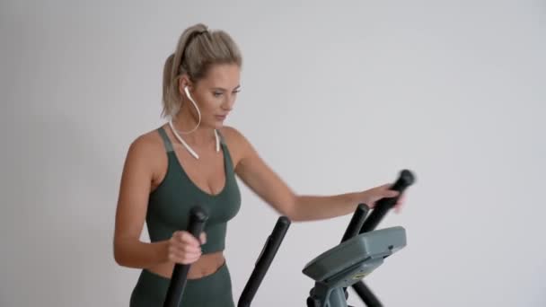 4K Hermosa mujer haciendo ejercicio en crosstrainer en casa — Vídeo de stock
