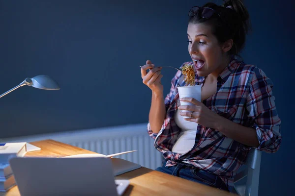 Estudante faminto comer macarrão enquanto aprende em casa — Fotografia de Stock