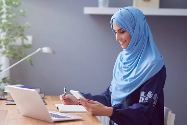 Muslim adult woman using smartphone — Stok fotoğraf