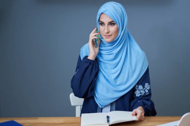 Muslim adult woman using smartphone