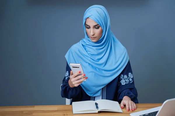 Muslim adult woman using smartphone — Stok fotoğraf