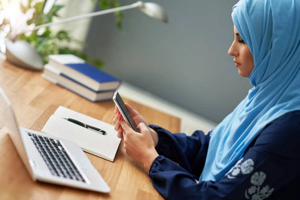 Mulher adulta muçulmana usando smartphone — Fotografia de Stock