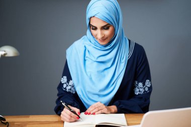 Muslim female student learning at home