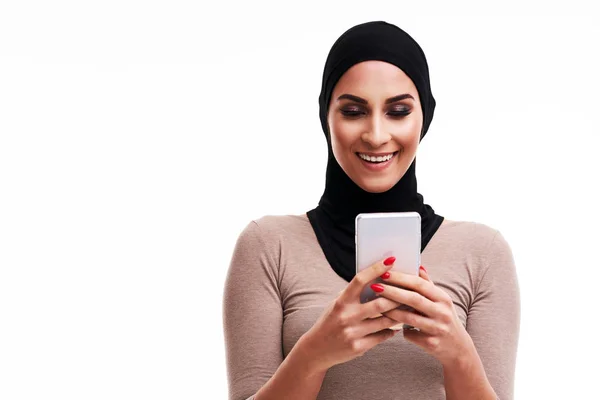 Mulher muçulmana usando smartphone sobre fundo branco — Fotografia de Stock