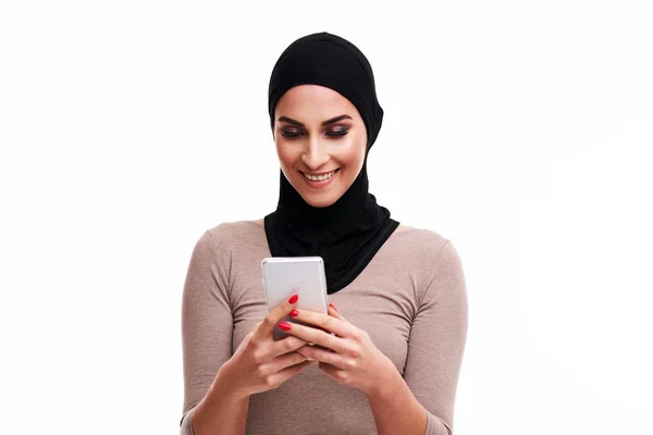 Μουσουλμάνα γυναίκα που χρησιμοποιεί smartphone πάνω από λευκό φόντο — Φωτογραφία Αρχείου