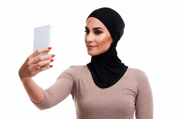 Muslimská žena pomocí smartphone přes bílé pozadí — Stock fotografie