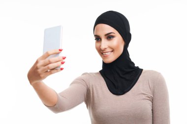 Muslim woman using smartphone over white background