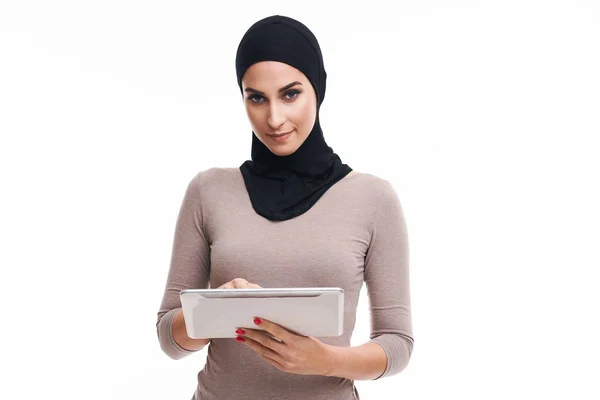 Muslimische Frau benutzt Tablette auf weißem Hintergrund — Stockfoto