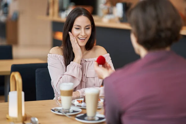 En ung mann frir til kjæresten sin på en kafe. – stockfoto