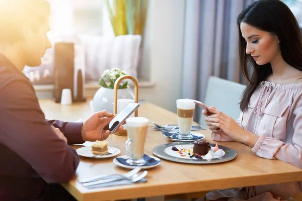 Молодая пара наслаждается кофе и торт в кафе — стоковое фото