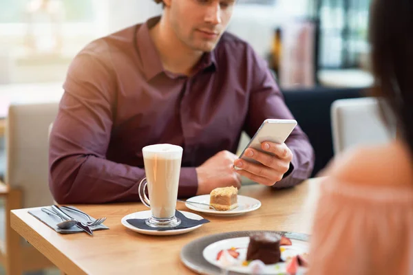 Jong koppel genieten van koffie en gebak in café — Stockfoto