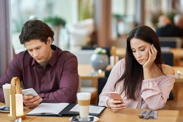 Junges Paar benutzt Smartphones im Cafe — Stockfoto