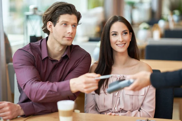 Young Couple paying by credit card in Cafe — Stock Photo, Image