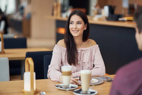 Jong koppel genieten van koffie en gebak in café — Stockfoto