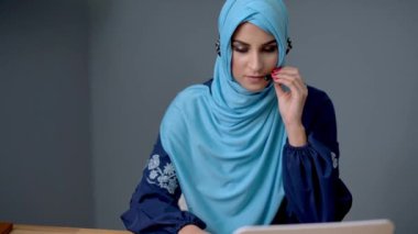 Bayan müslüman öğrenci evde öğreniyor.