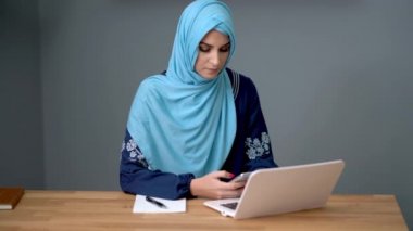 Bayan müslüman öğrenci evde öğreniyor.