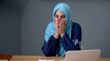 Bayan müslüman öğrenci evde öğreniyor.