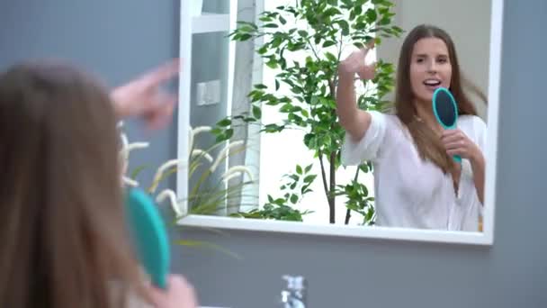 Feliz escovar o cabelo dançando e cantando no banheiro pela manhã — Vídeo de Stock