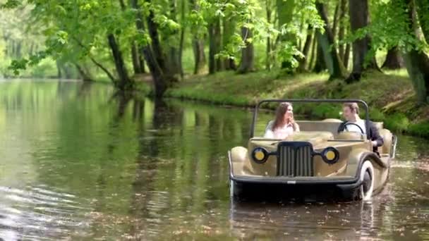 Adult couple on a relaxing date on pedalo in park — Stockvideo