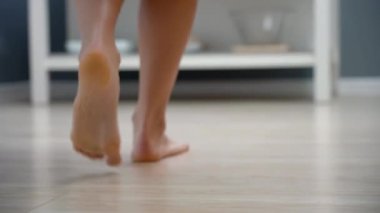 Female legs walking into bathroom in the morning