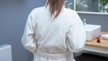 Adult woman checking weight on bathroom scales in the morning