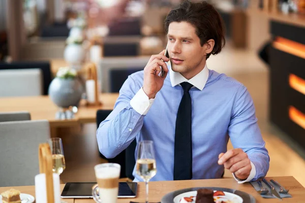 Zakenman met smartphone tijdens lunch in café — Stockfoto