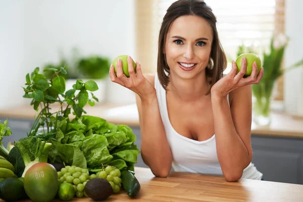 Femme adulte en bonne santé avec des aliments verts dans la cuisine — Photo