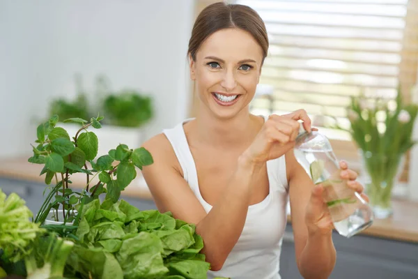 Donna adulta sana con cibo verde in cucina — Foto Stock