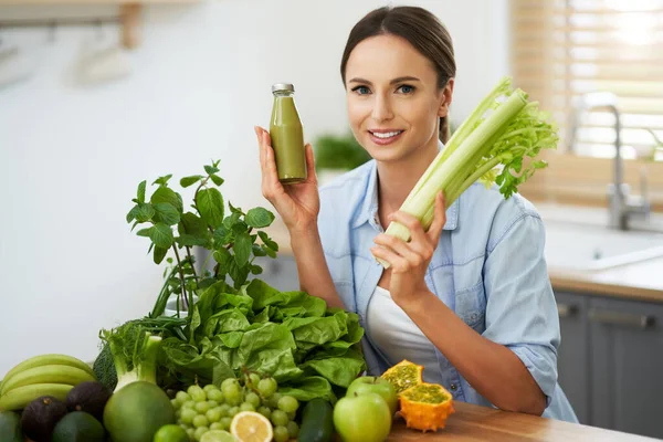 Donna adulta sana con cibo verde in cucina — Foto Stock