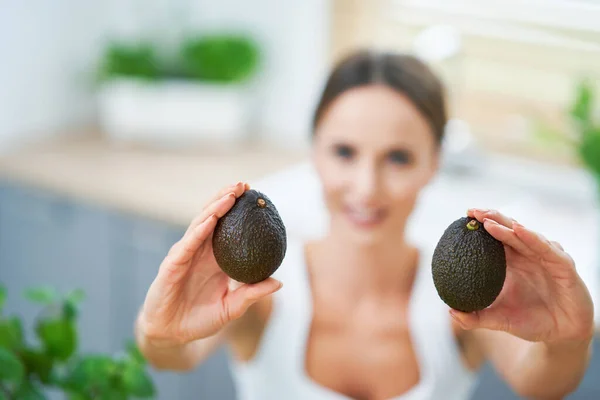 Mujer adulta saludable con comida verde en la cocina — Foto de Stock