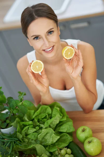 Mutfakta yeşil yemekleri olan sağlıklı yetişkin bir kadın. — Stok fotoğraf