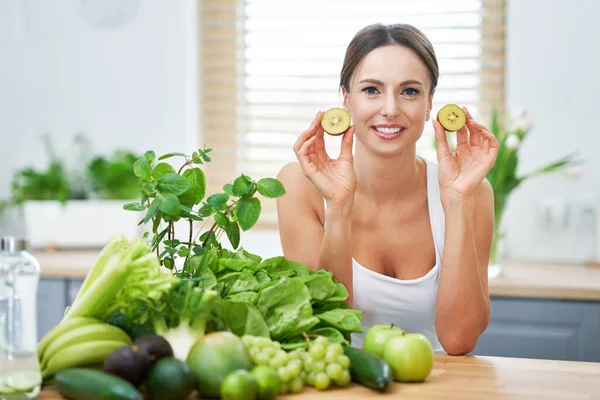 Femme adulte en bonne santé avec des aliments verts dans la cuisine — Photo