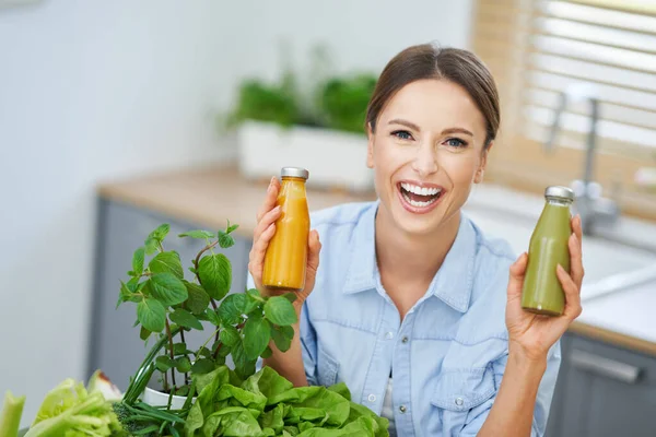 Gezonde volwassen vrouw met groen eten in de keuken — Stockfoto