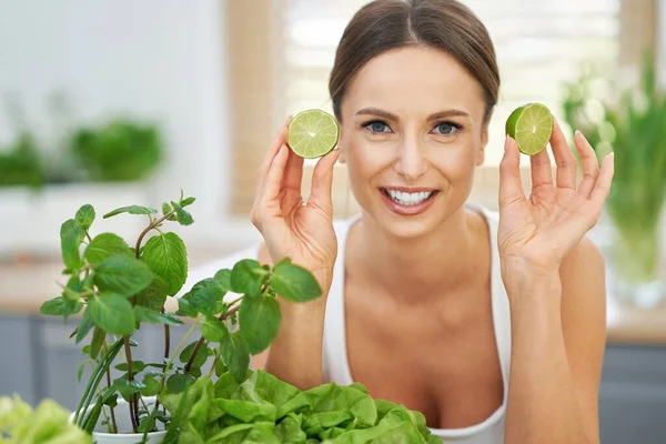 Mujer adulta saludable con comida verde en la cocina —  Fotos de Stock