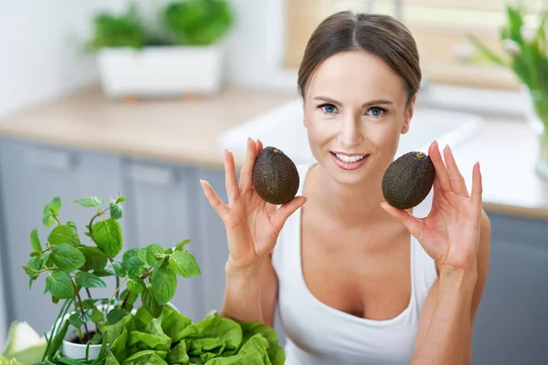 Mujer adulta saludable con comida verde en la cocina — Foto de Stock