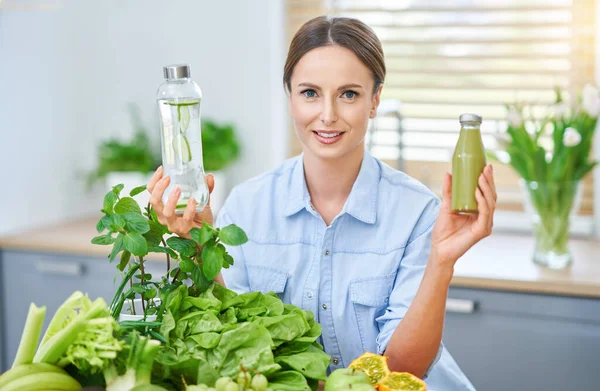 Gezonde volwassen vrouw met groen eten in de keuken — Stockfoto