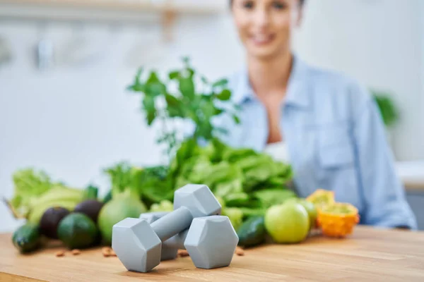 Mulher adulta saudável com comida verde na cozinha — Fotografia de Stock